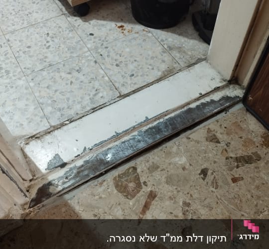 סף דלת מתכת על רצפת אריחים